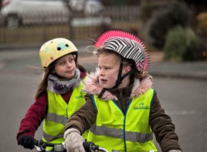 Two primary school girls practising riding on a bikeability course